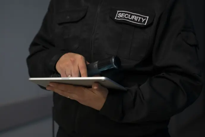 Agent de sécurité mobile en patrouille dans un complexe industriel, vérifiant les points sensibles et effectuant des rondes régulières pour prévenir les intrusions et les incidents.